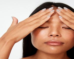 woman moisturizing face
