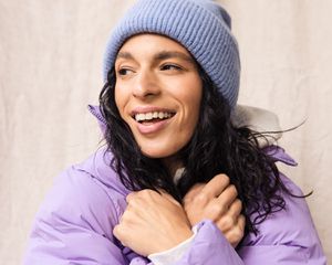 woman in purple jacket and blue hat