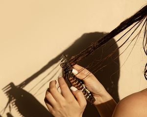 woman combing through wet hair