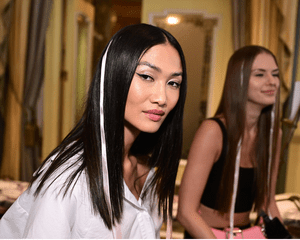 Model with straight hair and untied pale pink ribbons.