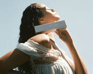 A woman holding up Emi Jay's Dream Créme hair mask.