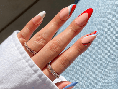 Close up of red, white, blue, orange, and purple swirl nails with accent French tips.