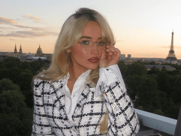 Sabrina Carpenter holding glasses. 